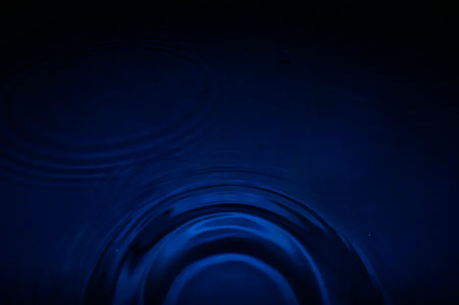 Two faint ripples meeting on dark water